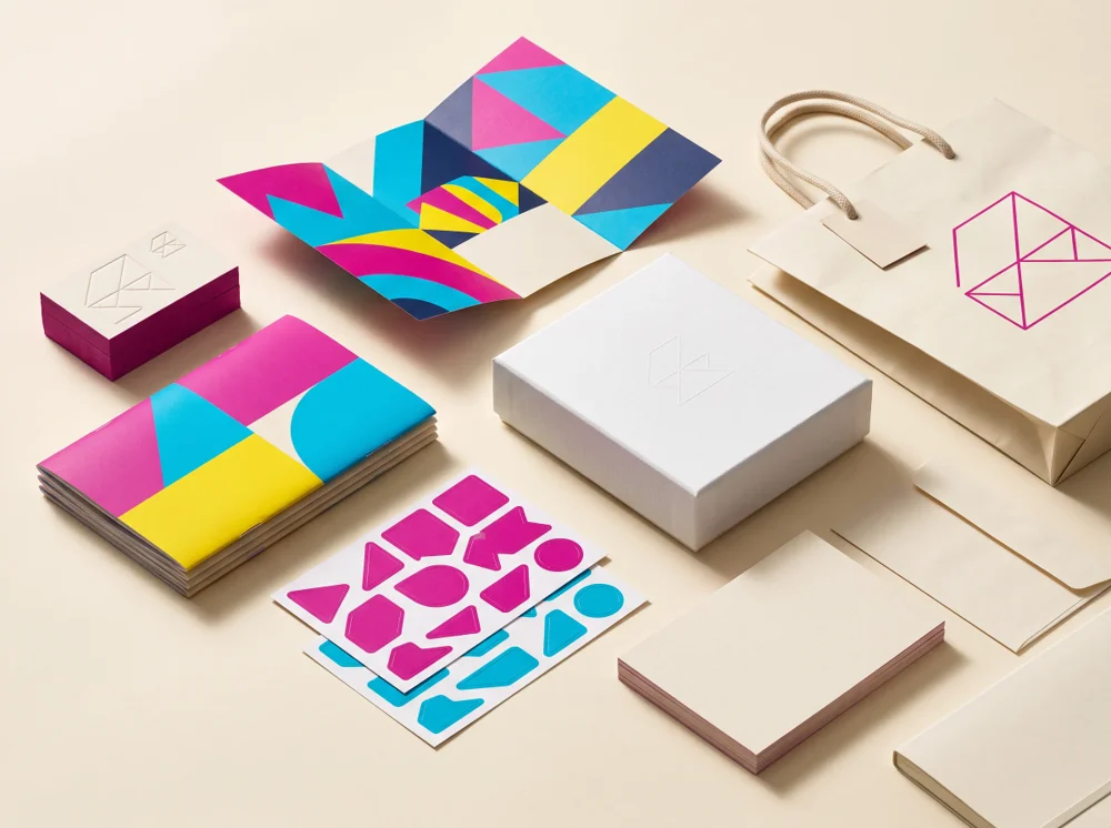 Representative premium print arrangement with colourful business cards, brochures, stickers and custom packaging